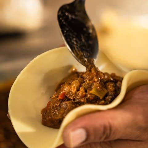 Guiso criollo servido a cuchara en la mesa