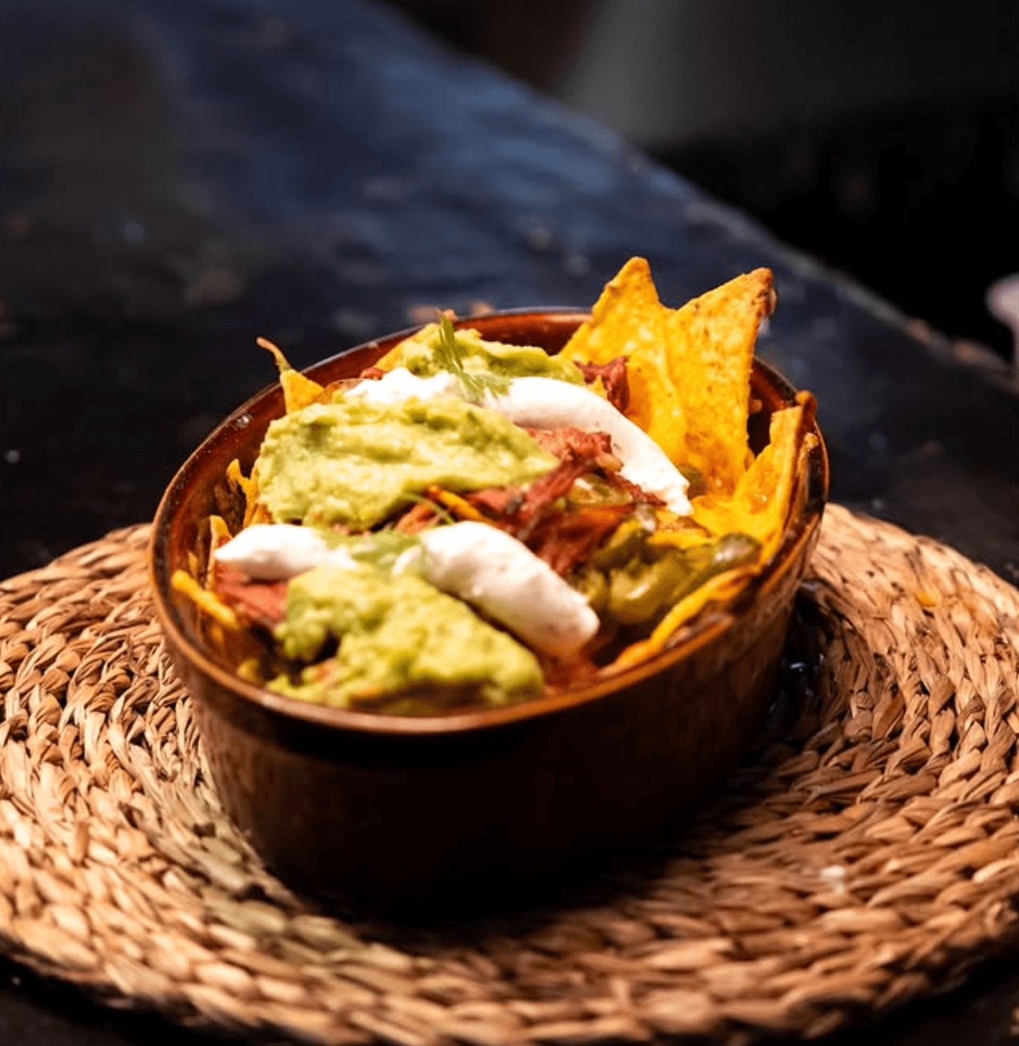Nachos con guacamole, crema y carne desmechada en cazuela de barro