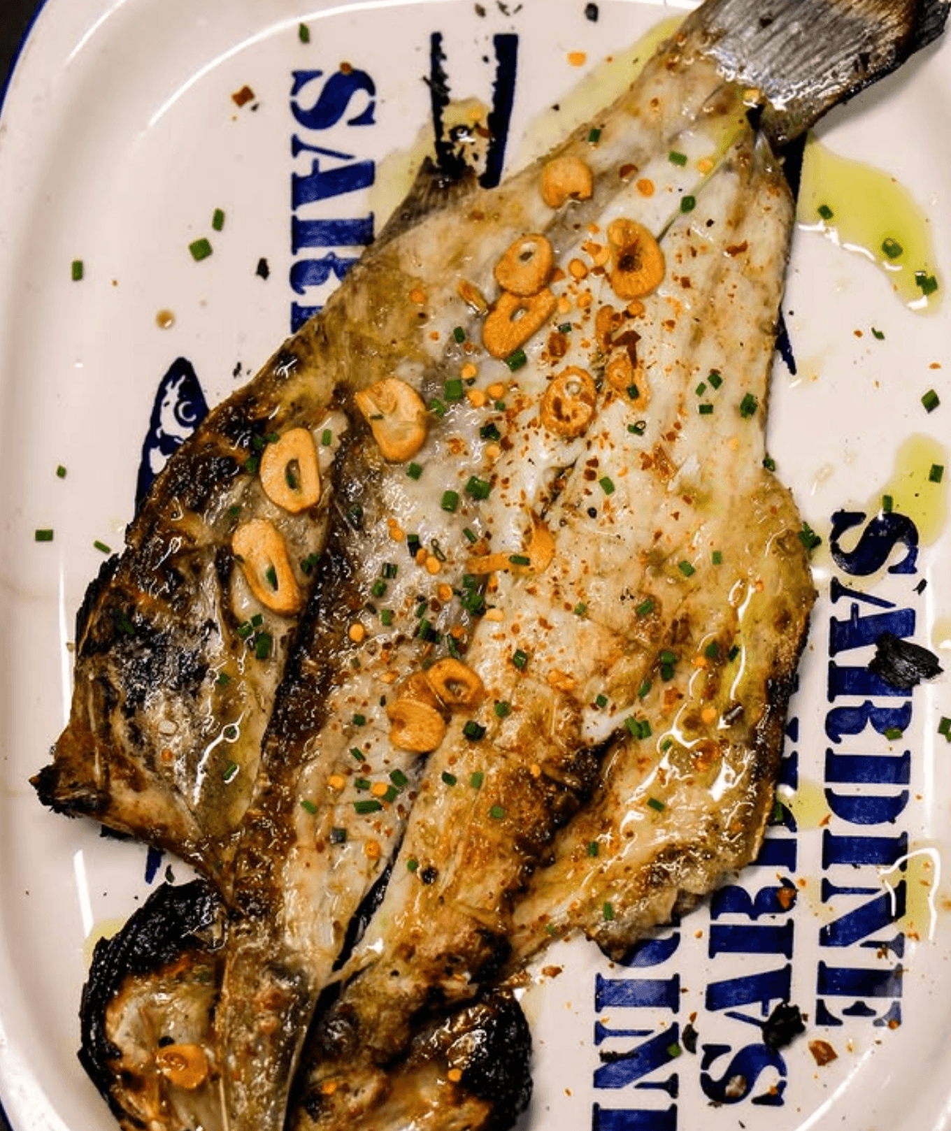 Pescado abierto a la parrilla con ajos y guindilla